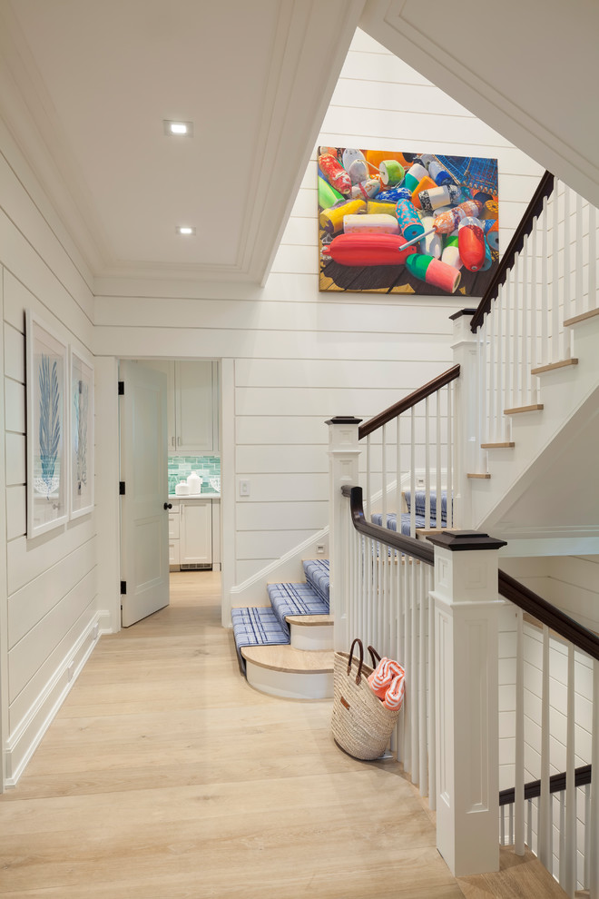This is an example of a beach style carpeted u-shaped staircase in Boston with carpet risers and wood railing.