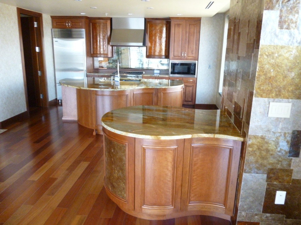Inspiration for a transitional medium tone wood floor kitchen remodel in Denver with an undermount sink, raised-panel cabinets, dark wood cabinets, granite countertops, brown backsplash, glass tile backsplash and white appliances