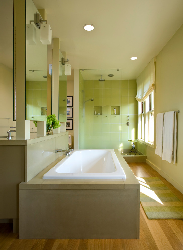 Inspiration for a transitional bathroom in San Francisco with a drop-in tub and green tile.