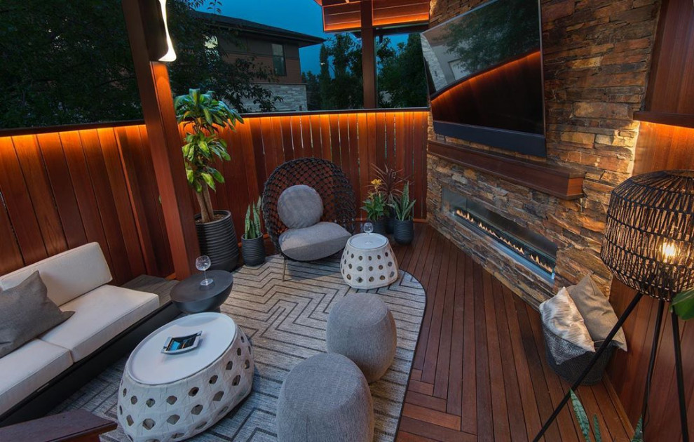 Mid-sized transitional backyard deck photo in Calgary with a fireplace