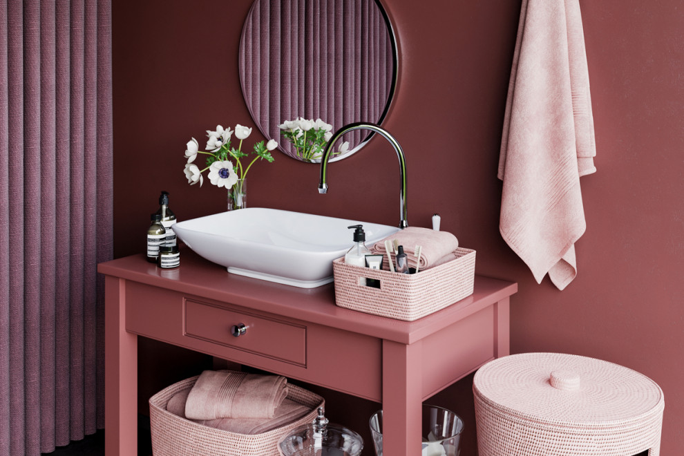 Cette image montre une salle de bain design avec WC à poser, un mur rose, une grande vasque, un sol beige, un plan de toilette rose, des toilettes cachées, meuble simple vasque et meuble-lavabo sur pied.