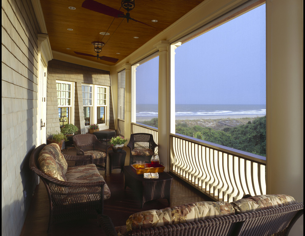 This is an example of a mid-sized beach style side yard verandah in Charleston with a roof extension.