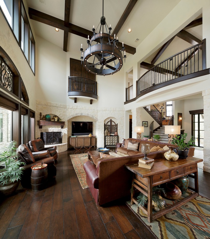 Large mediterranean open concept family room in Houston with dark hardwood floors, a corner fireplace and a stone fireplace surround.