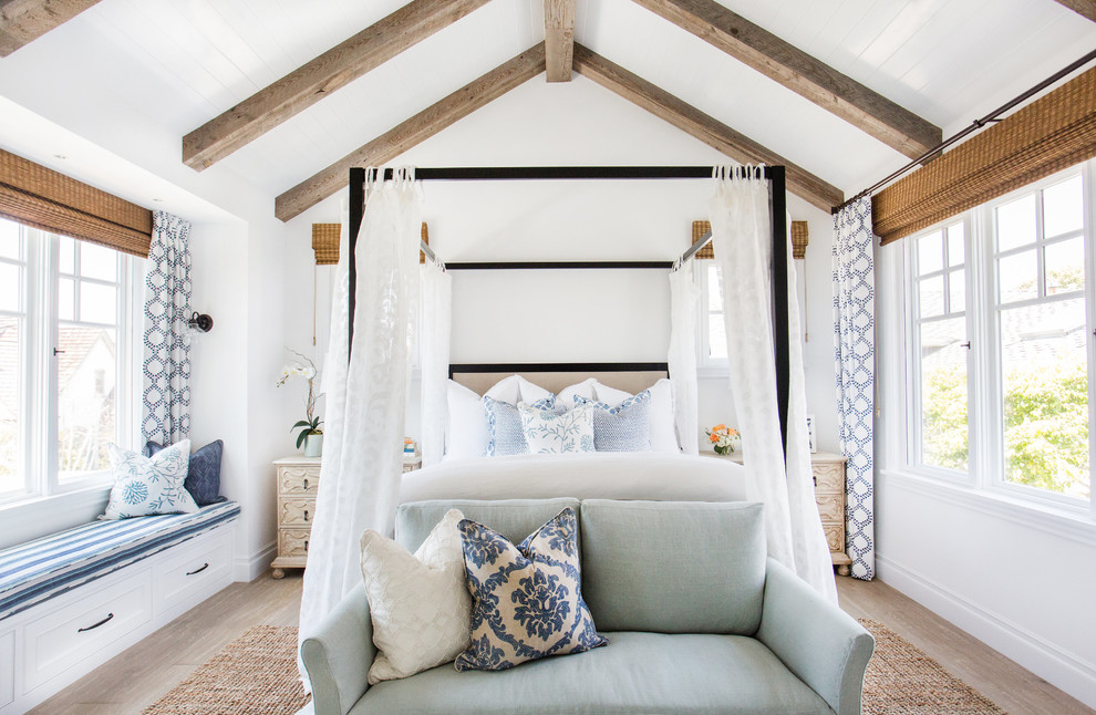 Inspiration for a mid-sized beach style master bedroom in Orange County with white walls and light hardwood floors.