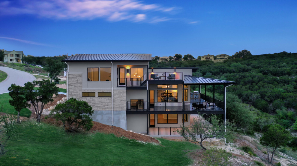 Dreistöckiges Modernes Einfamilienhaus mit Putzfassade, weißer Fassadenfarbe, Pultdach und schwarzem Dach in Austin