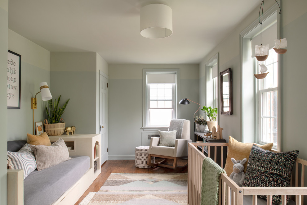 Serene Nursery - Example of a danish gender-neutral medium tone wood floor nursery design in Philadelphia with gray walls