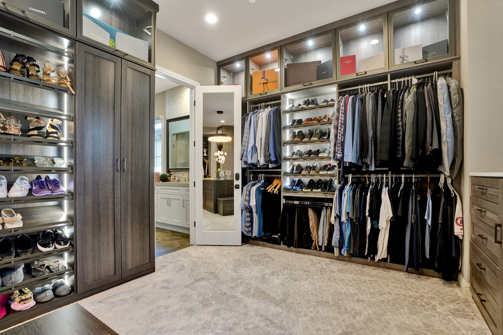 This is an example of a transitional storage and wardrobe in Orange County with shaker cabinets, dark wood cabinets and grey floor.