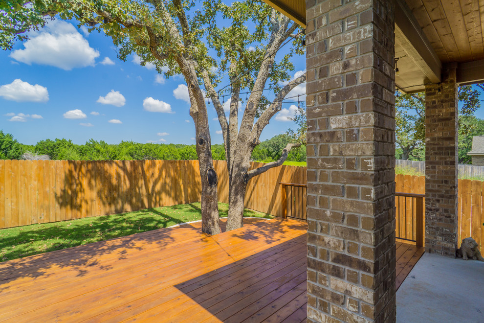 Deck - mid-sized rustic backyard deck idea in Austin with a roof extension