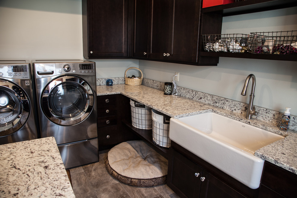 Transitional l-shaped laundry room in Other with an undermount sink, shaker cabinets, dark wood cabinets, granite benchtops, porcelain floors, a side-by-side washer and dryer and beige floor.
