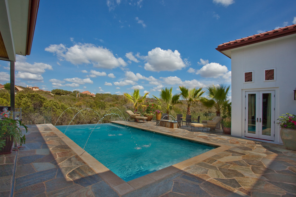 Pool - mid-sized rustic backyard stone and rectangular infinity pool idea in Austin