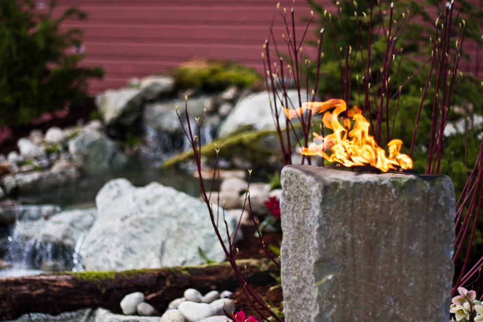 This is an example of a mid-sized rustic partial sun backyard stone formal garden in Seattle for spring.