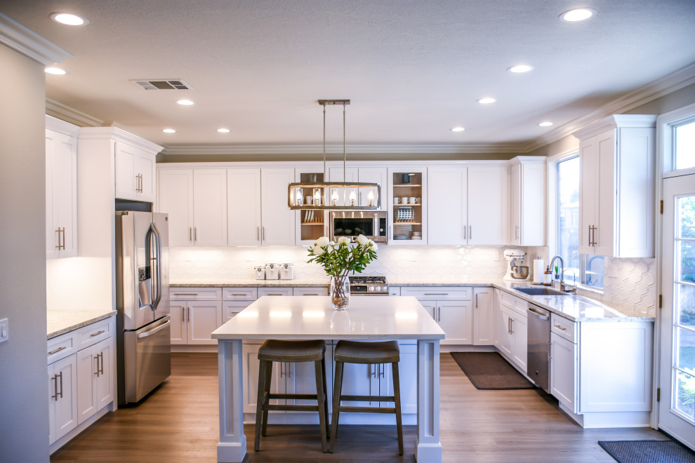 Eat-in kitchen - large transitional u-shaped light wood floor and beige floor eat-in kitchen idea in Phoenix with an undermount sink, shaker cabinets, white cabinets, quartzite countertops, white backsplash, ceramic backsplash, stainless steel appliances, an island and white countertops