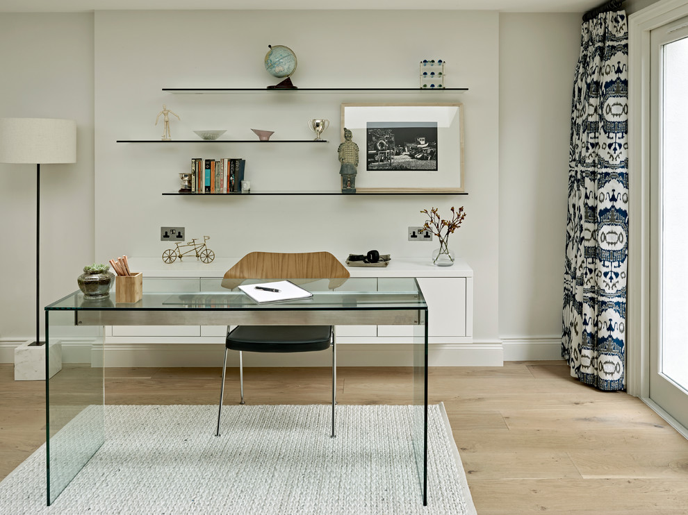 This is an example of a large transitional home office in London with grey walls, light hardwood floors, no fireplace, a freestanding desk and beige floor.