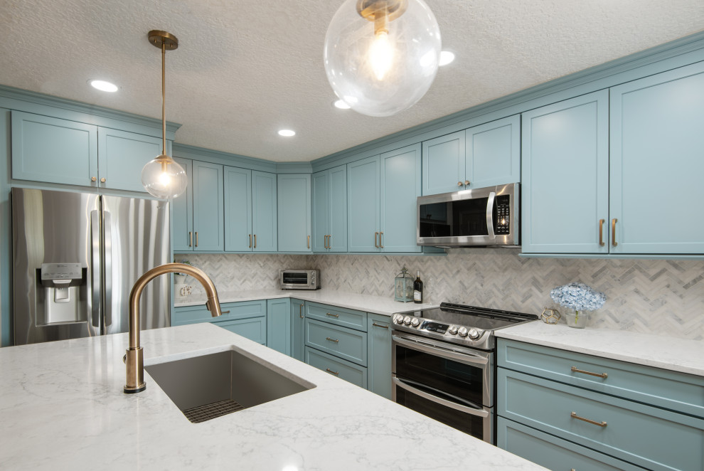 Photo of a mid-sized contemporary l-shaped eat-in kitchen in Tampa with an undermount sink, shaker cabinets, turquoise cabinets, quartz benchtops, white splashback, marble splashback, stainless steel appliances, vinyl floors, with island, beige floor and white benchtop.