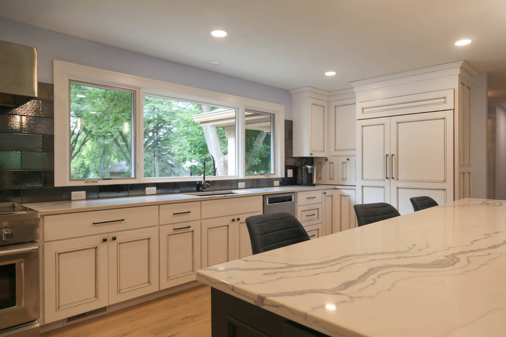 Inspiration for a mid-sized transitional u-shaped light wood floor and beige floor eat-in kitchen remodel with an undermount sink, recessed-panel cabinets, white cabinets, quartzite countertops, black backsplash, porcelain backsplash, stainless steel appliances, an island and white countertops