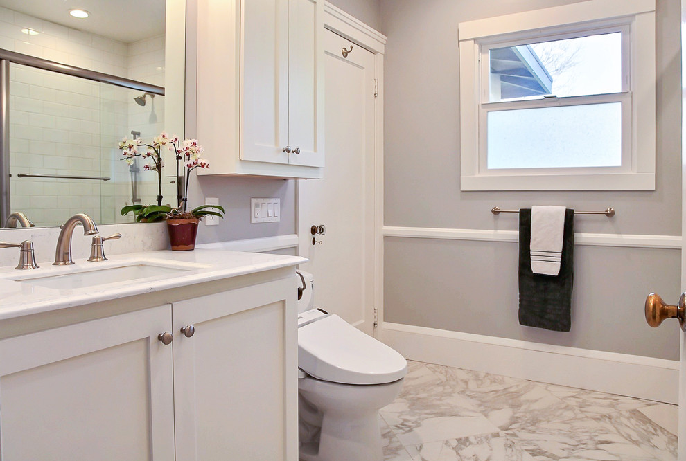 This is an example of a mid-sized traditional master bathroom in San Francisco with recessed-panel cabinets, white cabinets, a bidet, white tile, a drop-in tub, a shower/bathtub combo, white walls, linoleum floors and a pedestal sink.