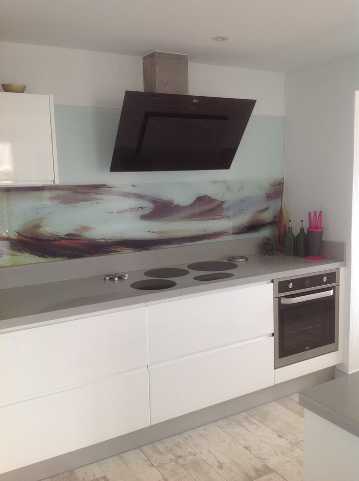 Design ideas for a small contemporary u-shaped kitchen in Other with grey splashback and stainless steel appliances.