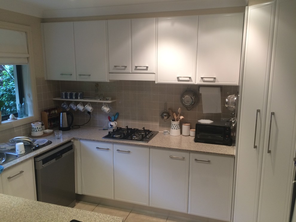 Photo of a mid-sized modern kitchen in Sydney with shaker cabinets and white cabinets.