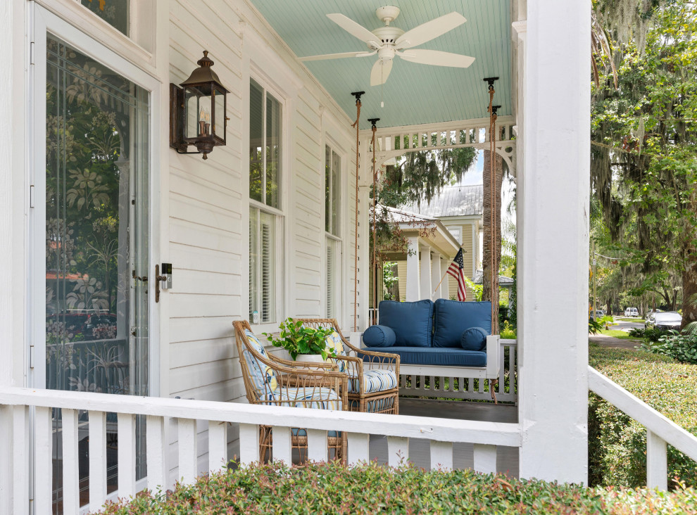 Design ideas for a mid-sized traditional front yard verandah in Atlanta with with columns, a roof extension and wood railing.