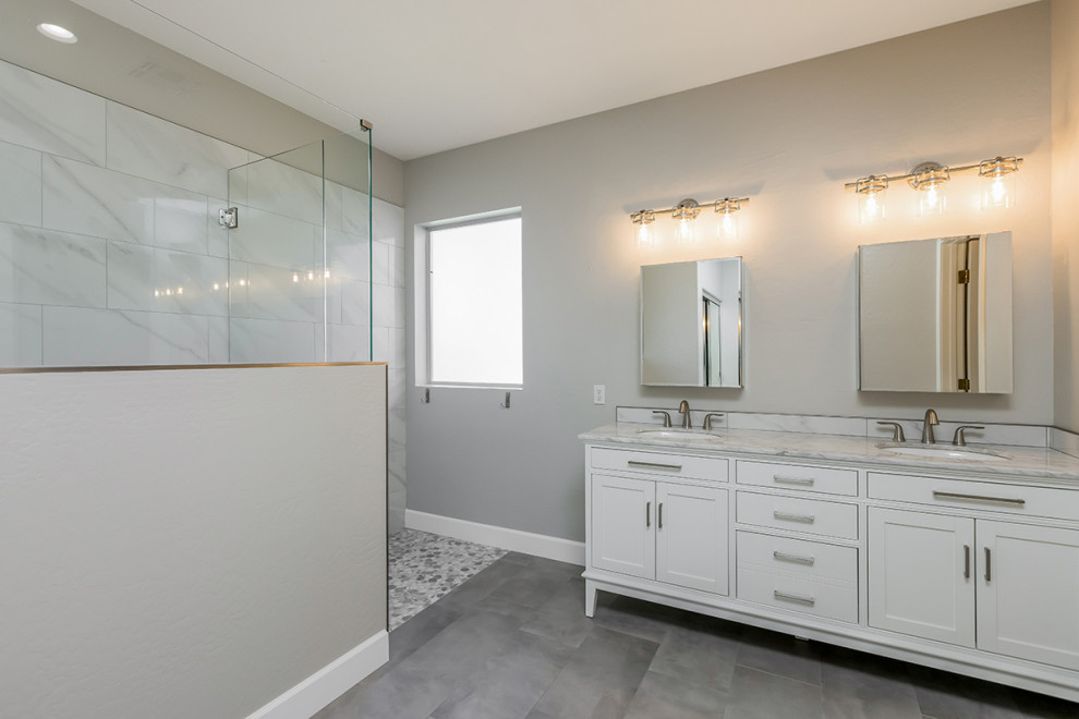 Klassisk inredning av ett mellanstort vit vitt en-suite badrum, med skåp i shakerstil, vita skåp, en dusch i en alkov, vit kakel, porslinskakel, grå väggar, klinkergolv i porslin, ett undermonterad handfat, marmorbänkskiva, grått golv och dusch med gångjärnsdörr