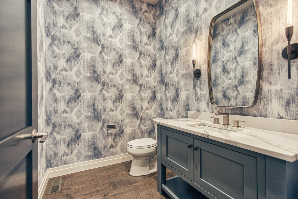 Bathroom - large transitional 3/4 medium tone wood floor and brown floor bathroom idea with shaker cabinets, blue cabinets, a two-piece toilet, multicolored walls, a vessel sink, quartz countertops and white countertops