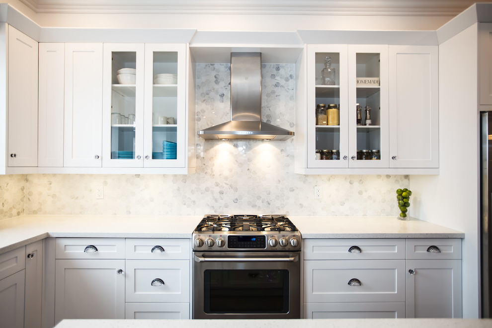 This is an example of a mid-sized transitional galley eat-in kitchen in Toronto with an undermount sink, shaker cabinets, white cabinets, granite benchtops, white splashback, stone tile splashback, stainless steel appliances, dark hardwood floors and with island.