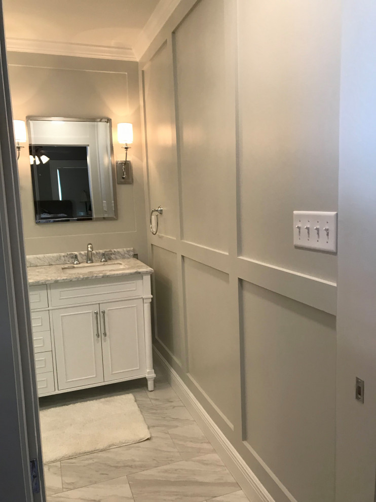 Photo of a transitional master bathroom in Houston with beaded inset cabinets, white cabinets, a double shower, porcelain tile, grey walls, marble benchtops, white floor, a hinged shower door, white benchtops, a niche, a double vanity, a freestanding vanity and decorative wall panelling.