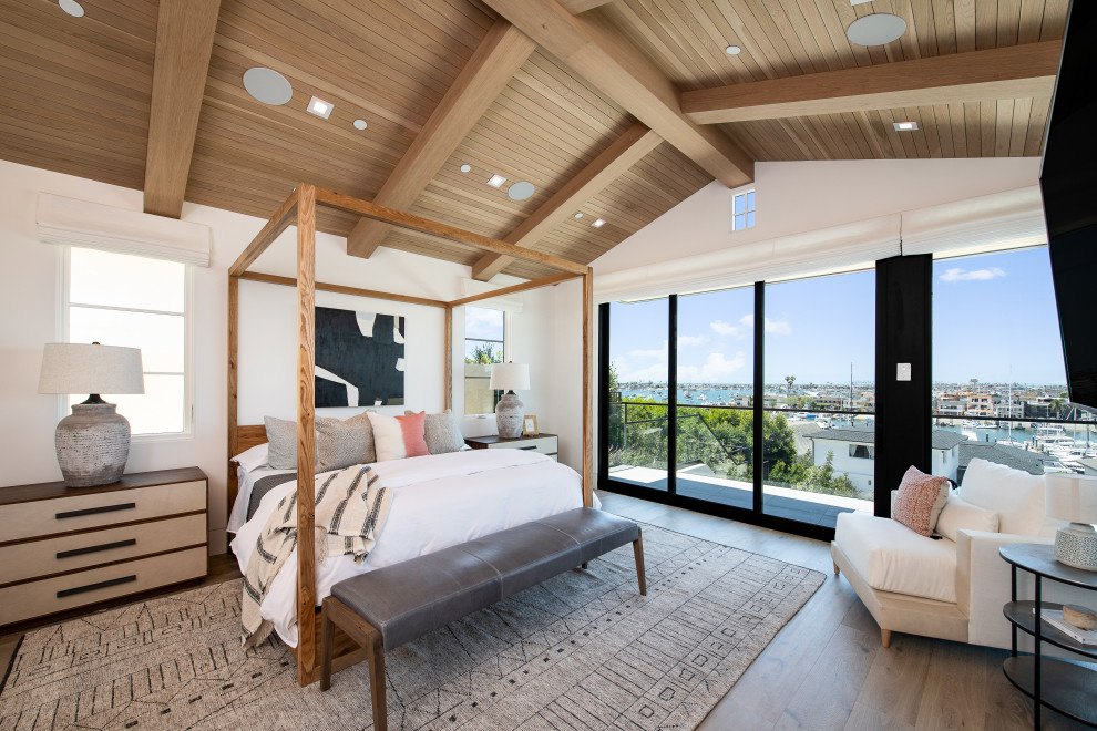 Example of a large transitional master light wood floor, brown floor, vaulted ceiling and wood ceiling bedroom design in Orange County with beige walls, a ribbon fireplace and a stone fireplace