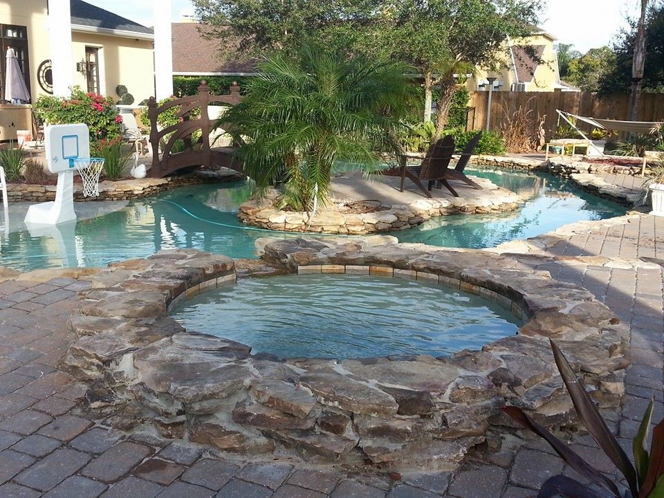 Design ideas for a large backyard round natural pool in San Diego with a water feature and natural stone pavers.