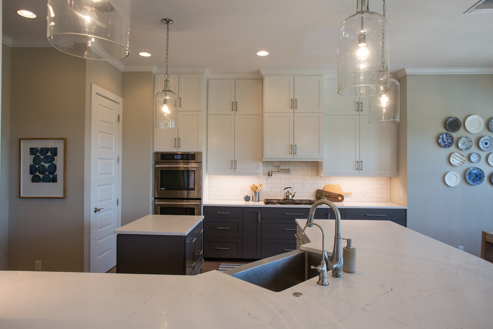 Transitional light wood floor and beige floor eat-in kitchen photo in Austin with a farmhouse sink, shaker cabinets, white cabinets, quartz countertops, white backsplash, subway tile backsplash, stainless steel appliances and an island