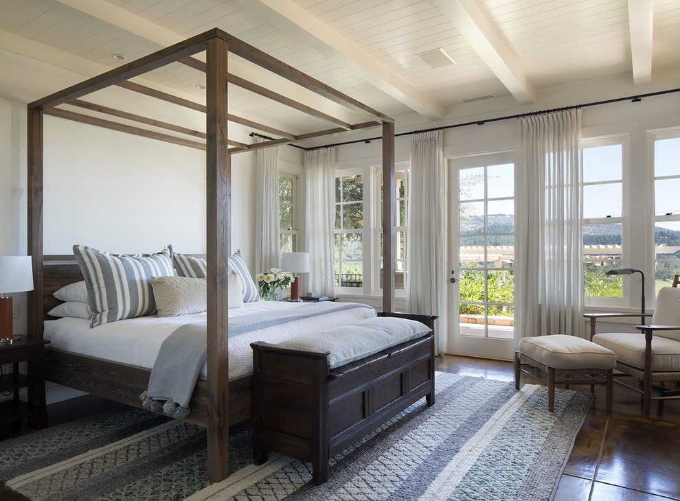 Country master bedroom in San Francisco with white walls, brown floor and concrete floors.