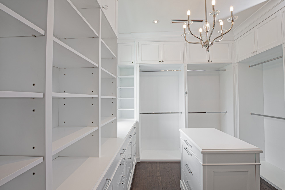 This is an example of a large traditional walk-in wardrobe in Miami with beaded inset cabinets, dark wood cabinets, dark hardwood floors and brown floor.