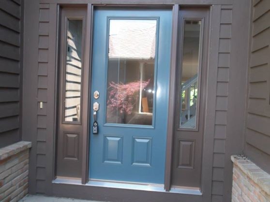 Photo of a transitional front door in Cleveland with brown walls, ceramic floors, a single front door and a medium wood front door.