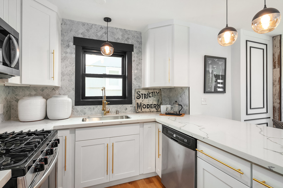 Inspiration for a transitional u-shaped medium tone wood floor and brown floor kitchen remodel in Seattle with an undermount sink, shaker cabinets, gray backsplash, stainless steel appliances, a peninsula and white countertops