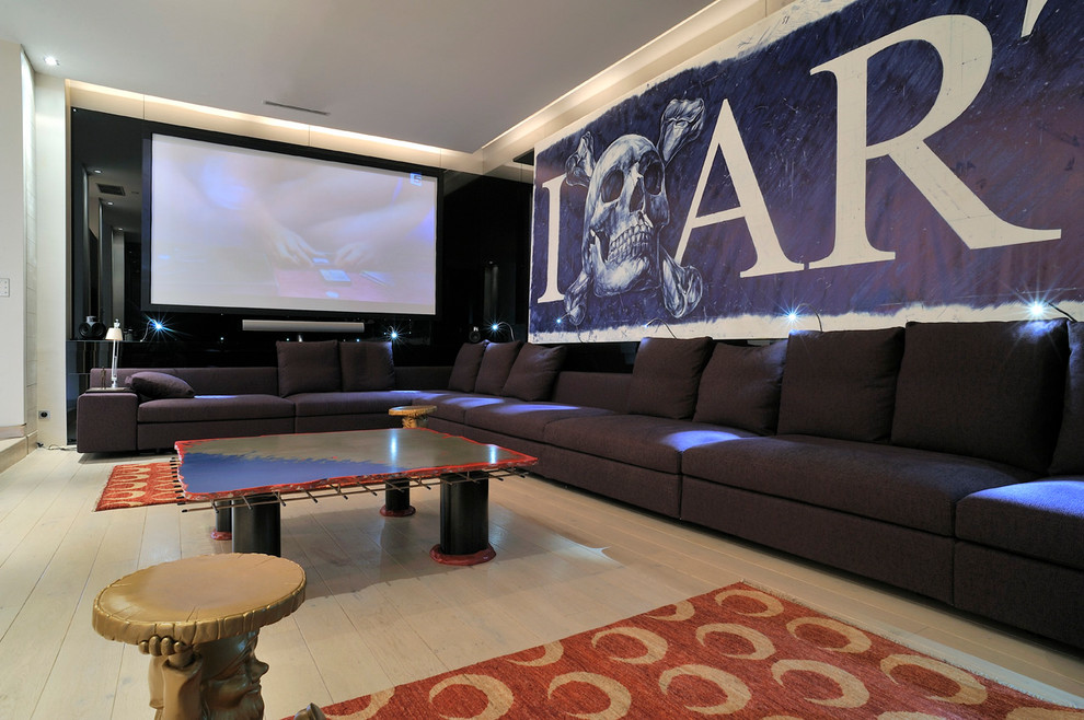 Photo of a large contemporary enclosed home theatre in Lyon with white walls, light hardwood floors and a projector screen.