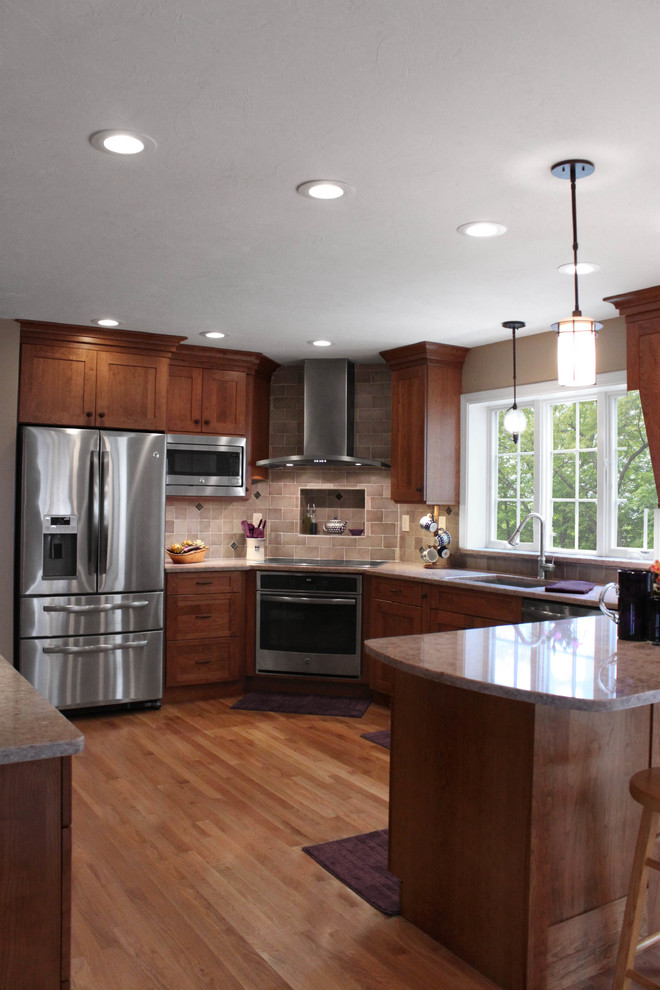 Large transitional u-shaped light wood floor eat-in kitchen photo in Boston with an undermount sink, shaker cabinets, medium tone wood cabinets, quartz countertops, gray backsplash, porcelain backsplash, stainless steel appliances and a peninsula