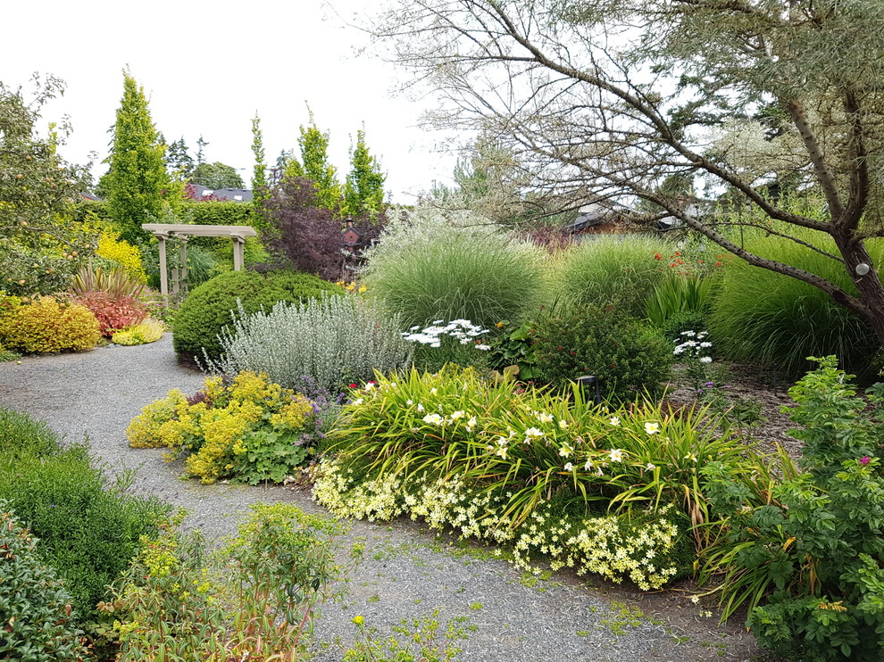 Photo of an expansive mediterranean backyard full sun xeriscape in Vancouver with gravel.