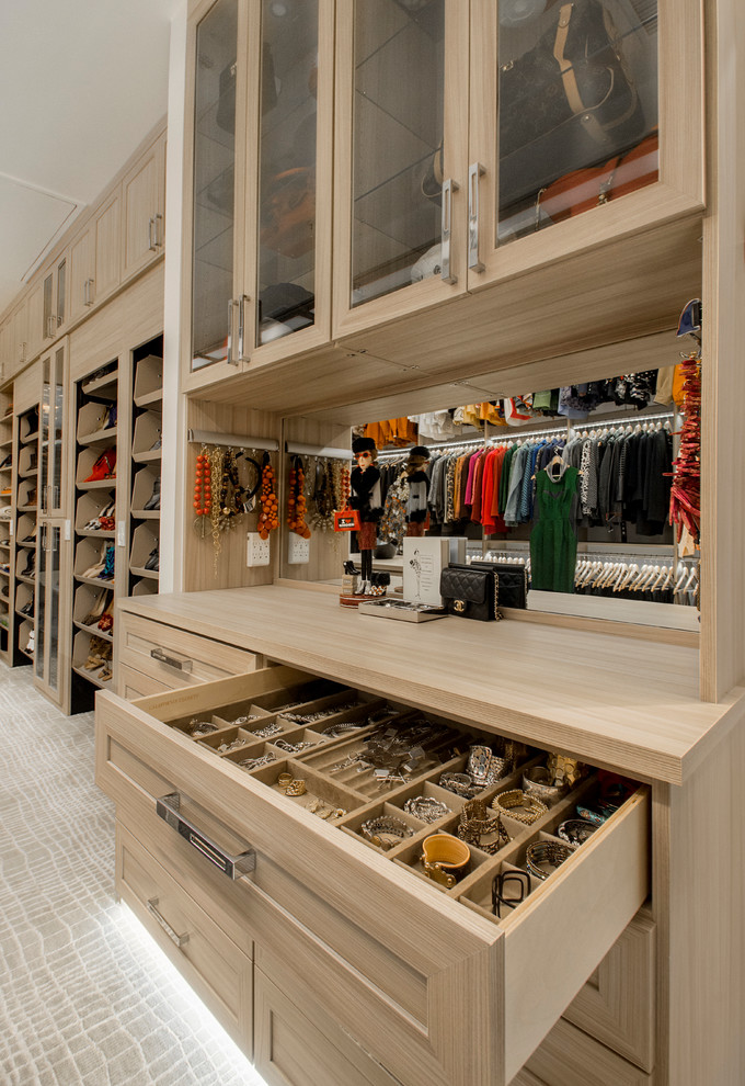 Large transitional gender-neutral walk-in wardrobe in Dallas with shaker cabinets, light wood cabinets and carpet.