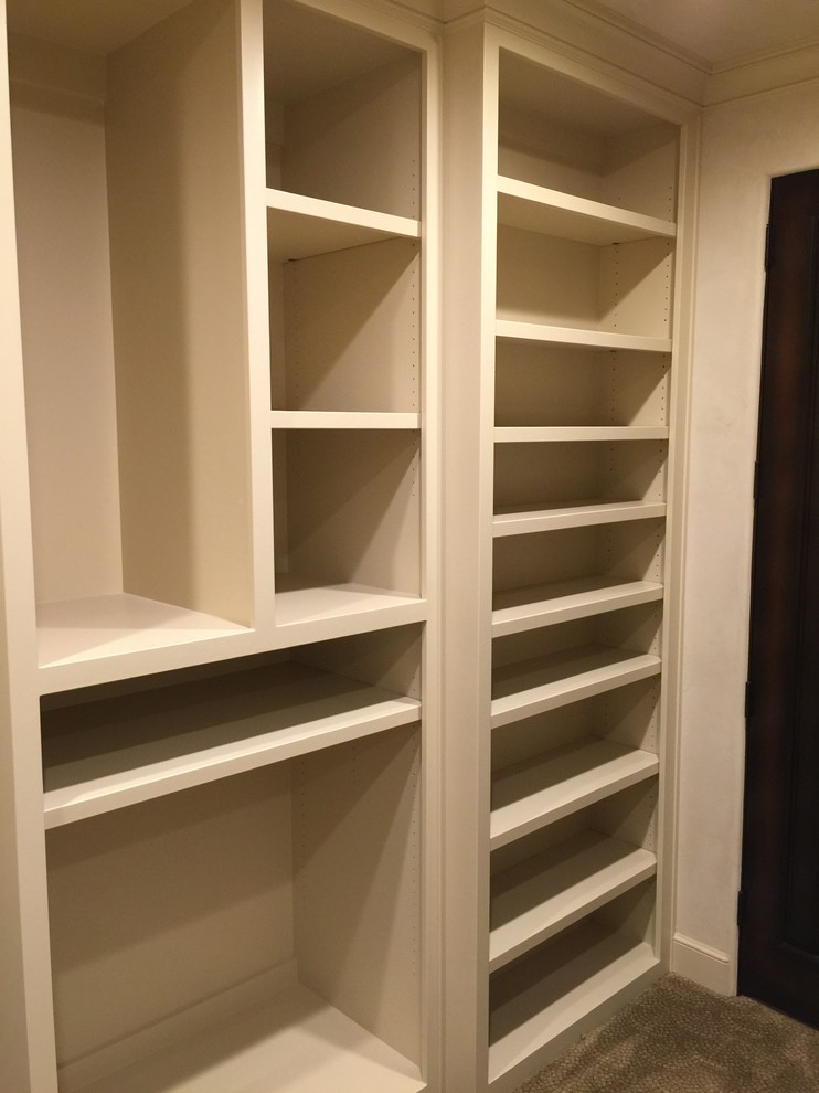 This is an example of a mediterranean walk-in wardrobe in Austin with carpet.