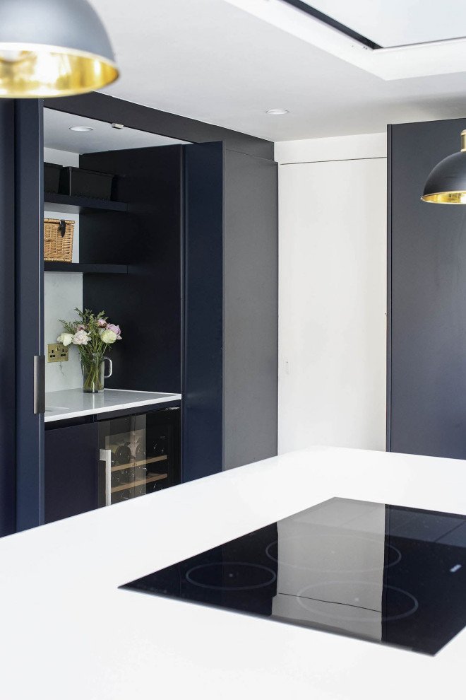 Inspiration for a small contemporary l-shaped open plan kitchen in London with a submerged sink, beaded cabinets, black cabinets, quartz worktops, white splashback, ceramic splashback, black appliances, ceramic flooring, an island, multi-coloured floors, white worktops, a vaulted ceiling and feature lighting.