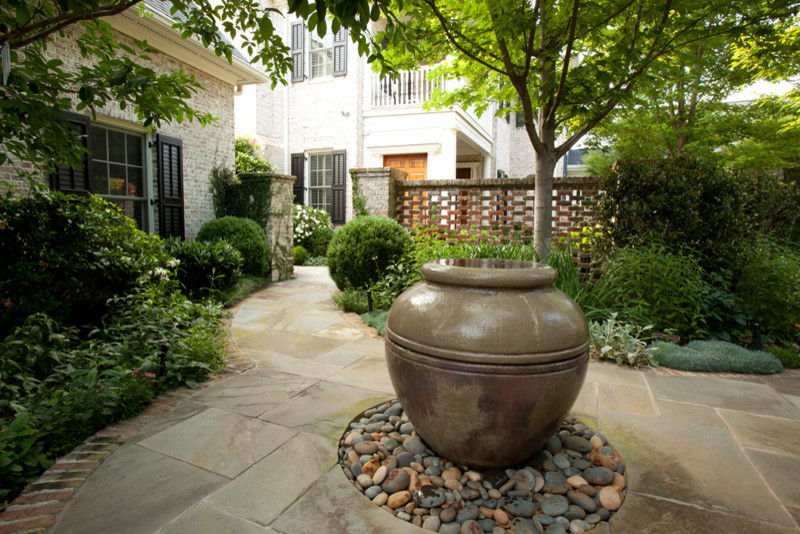 Design ideas for an expansive traditional backyard shaded garden in Other with a water feature and brick pavers.