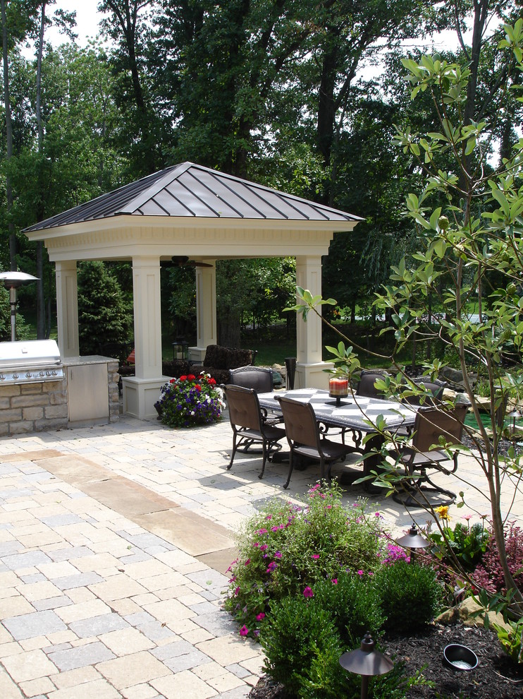 Esempio di un patio o portico di medie dimensioni e dietro casa con fontane, pavimentazioni in pietra naturale e una pergola