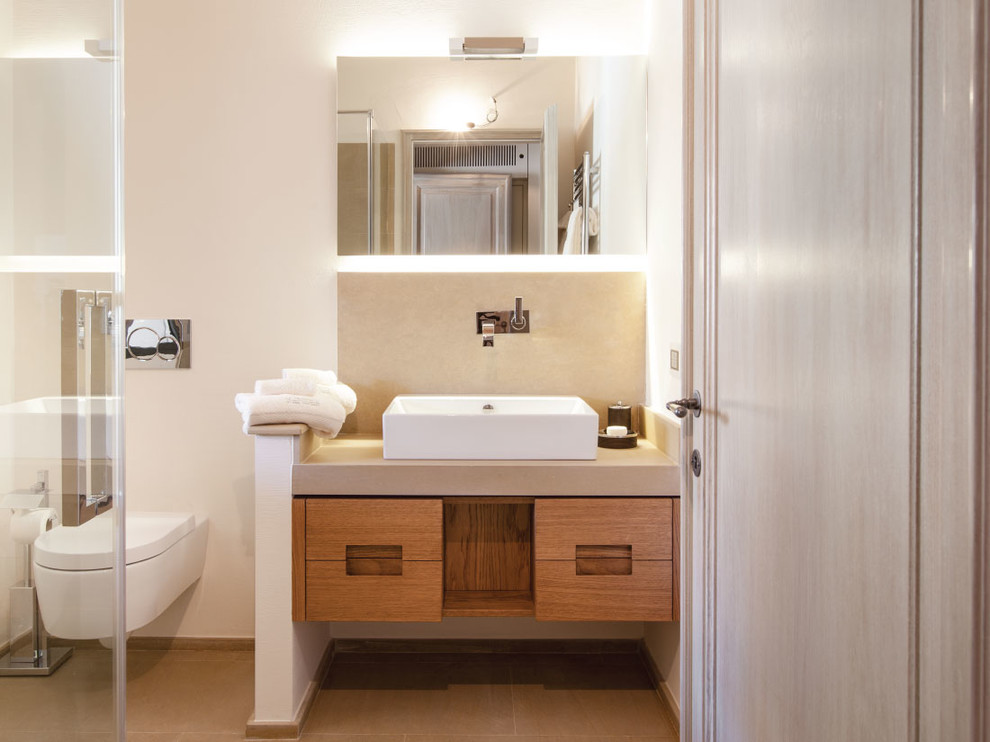 Inspiration for a contemporary bathroom in Florence with a wall-mount toilet, beige walls and a vessel sink.