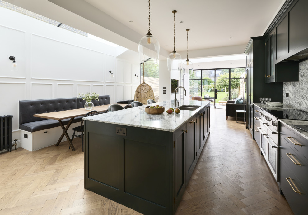 Large classic kitchen/diner in London with a submerged sink, shaker cabinets, green cabinets, marble worktops, grey splashback, marble splashback, stainless steel appliances, medium hardwood flooring, an island and grey worktops.