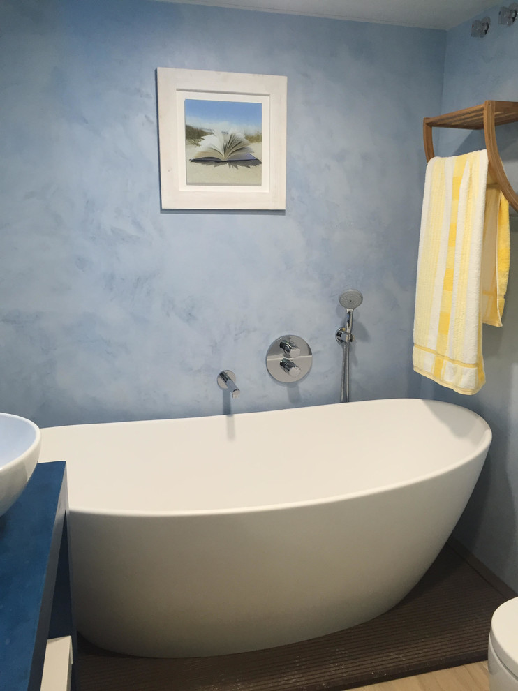 This is an example of a mid-sized beach style master bathroom in Other with a freestanding tub, a shower/bathtub combo, blue walls and a vessel sink.