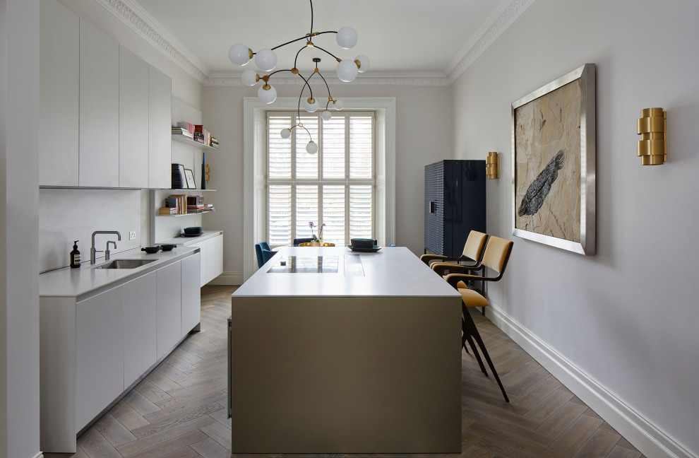 This is an example of a large contemporary single-wall eat-in kitchen in London with a single-bowl sink, flat-panel cabinets, solid surface benchtops, white splashback, medium hardwood floors, with island, grey floor and coffered.