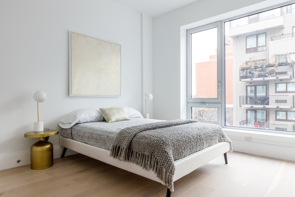 Danish guest light wood floor and beige floor bedroom photo in New York with gray walls