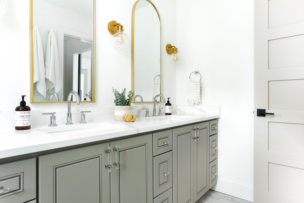 This is an example of a transitional bathroom in Dallas with raised-panel cabinets, grey cabinets, white walls, an undermount sink, grey floor, white benchtops and a double vanity.