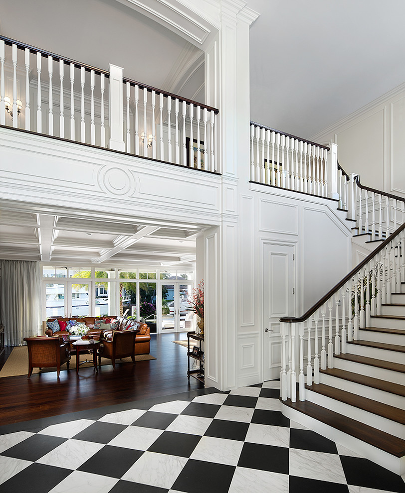 Photo of a large traditional foyer in Miami with white walls, marble floors, a double front door and a dark wood front door.