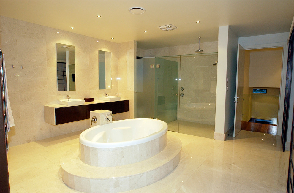 Photo of a large asian master bathroom in Brisbane with flat-panel cabinets, dark wood cabinets, a hot tub, an alcove shower, beige walls, porcelain floors, a vessel sink, beige floor and a hinged shower door.